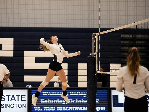 Woman spikes ball during volleyball game