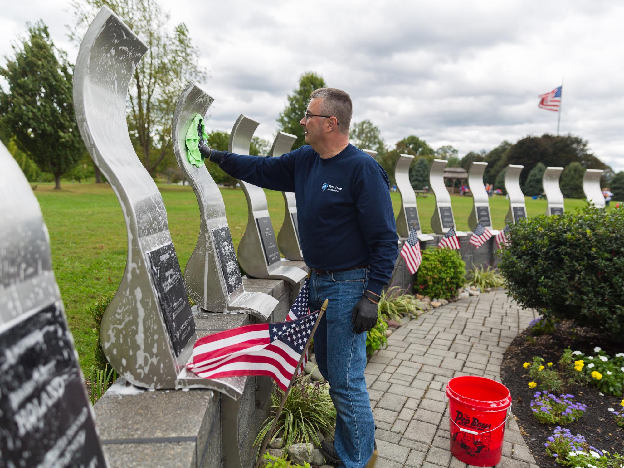 Bill Tyson cleans the Delaware County Law Enforcement Memorial