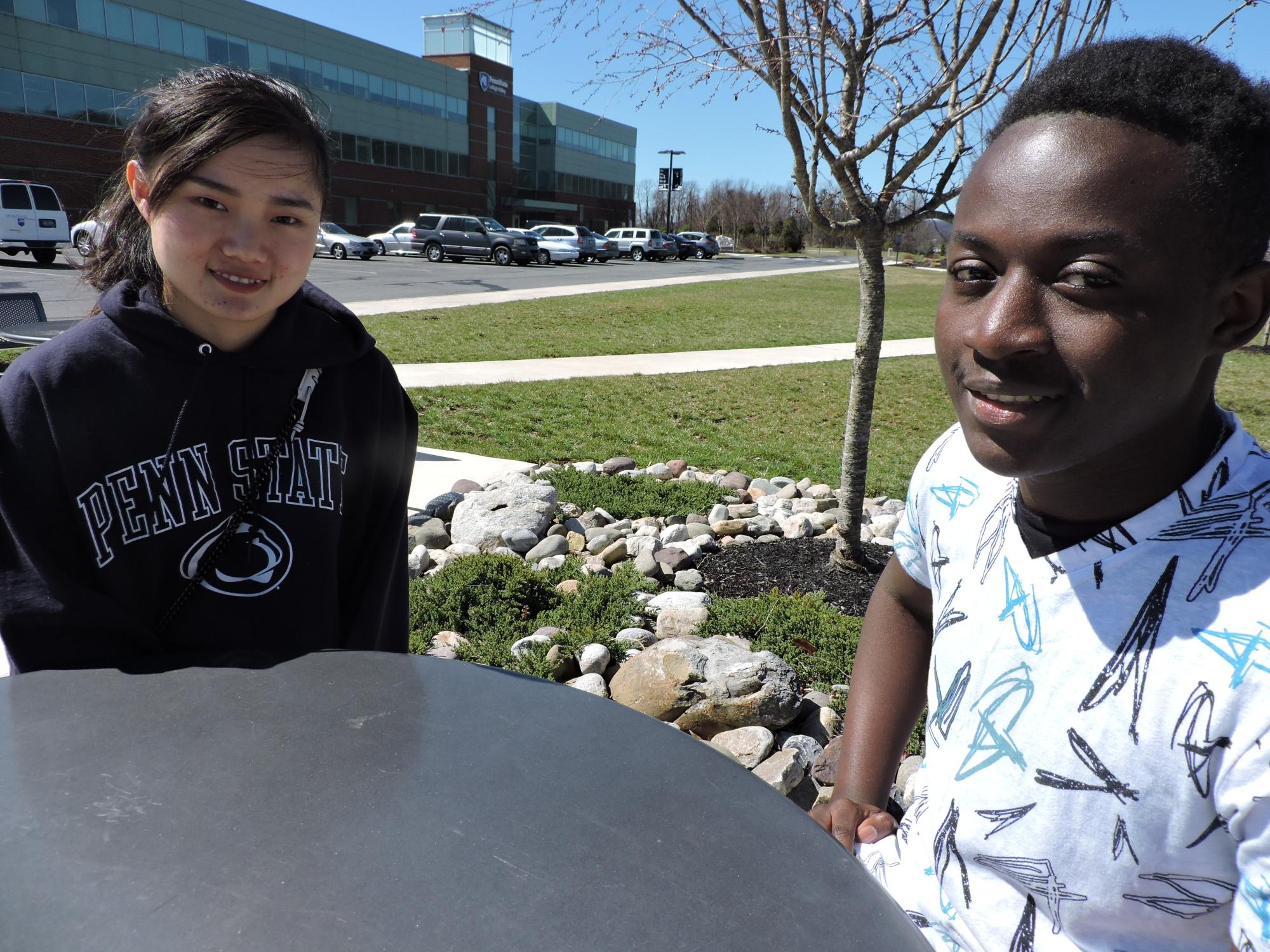 Two students sitting at a table outside of campus