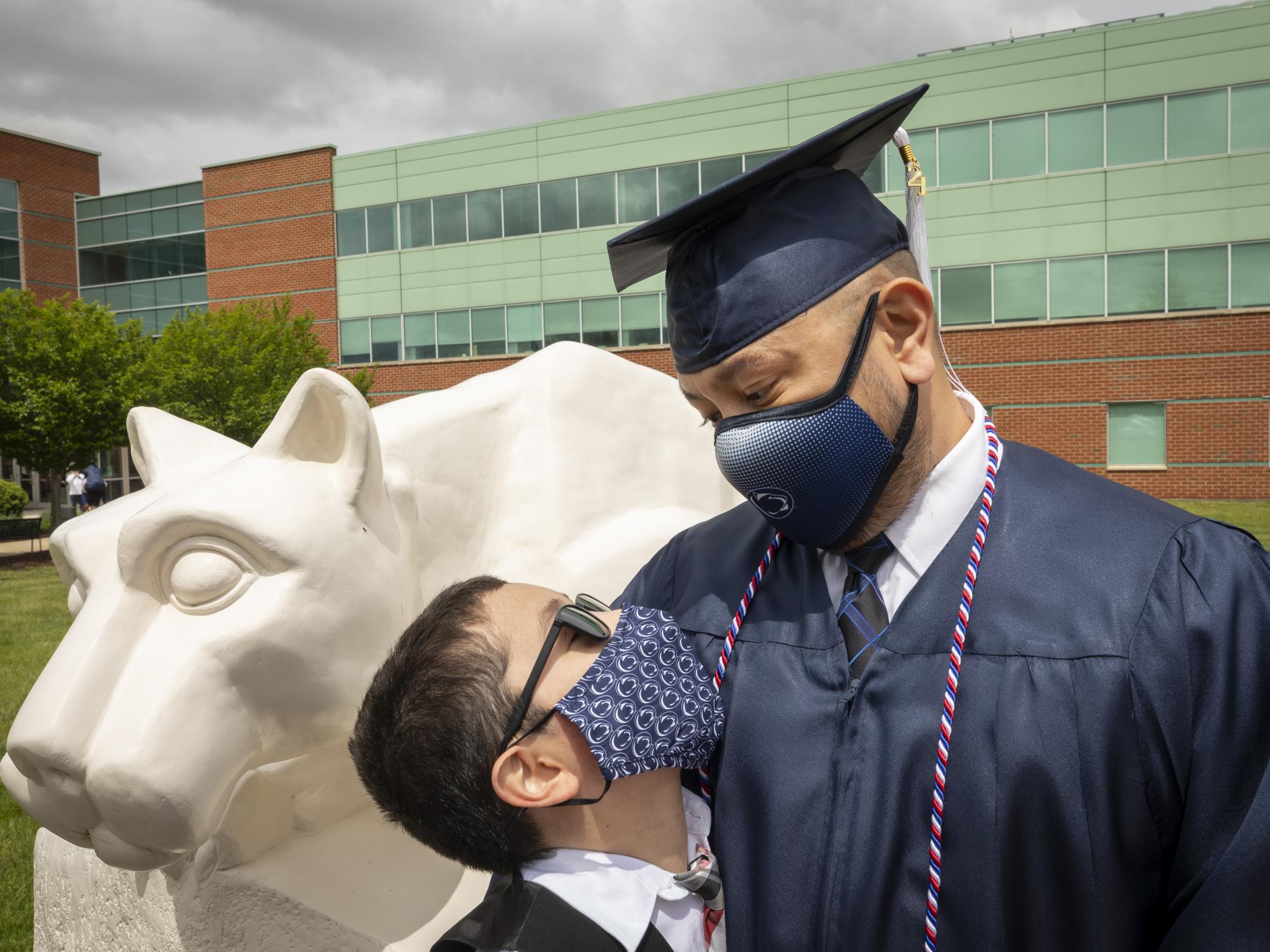 boy looking up at man in cap and gown