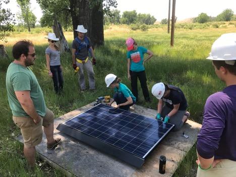 Students practice making connections between solar module and roof