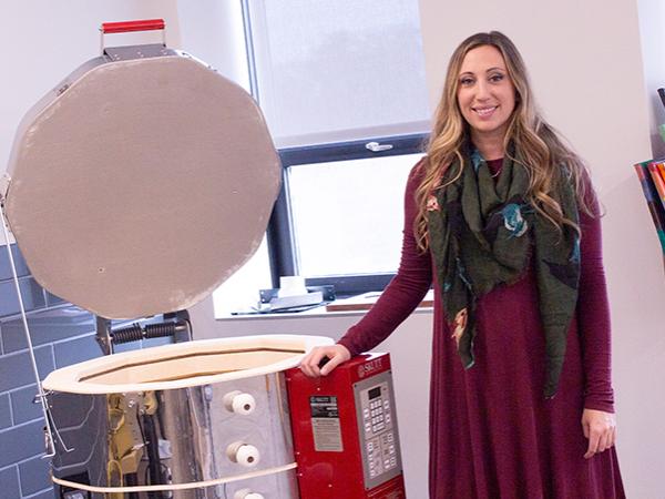 Lecturer in Art, Corianne Thompson stands near kiln in the new art studio 