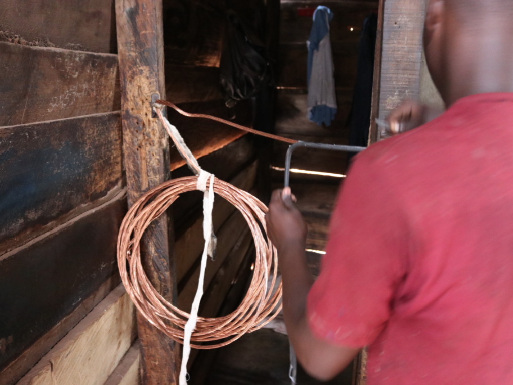boy peels insulation from copper wire