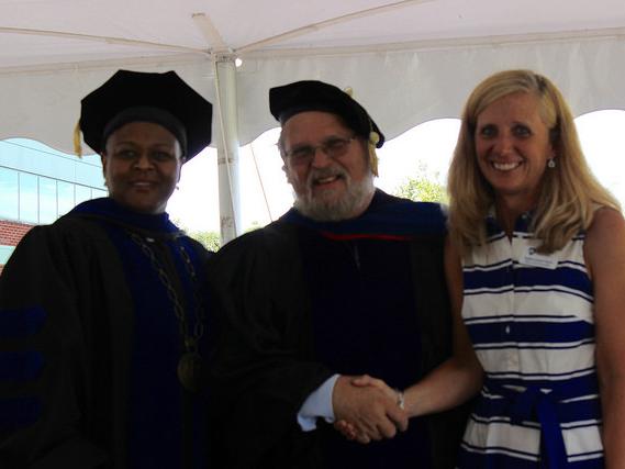three people pose during award ceremony