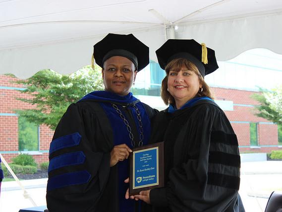 women pose with a plaque
