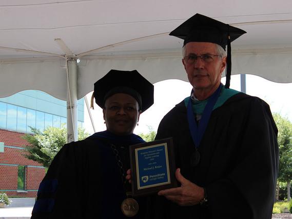 two people posed with plaque