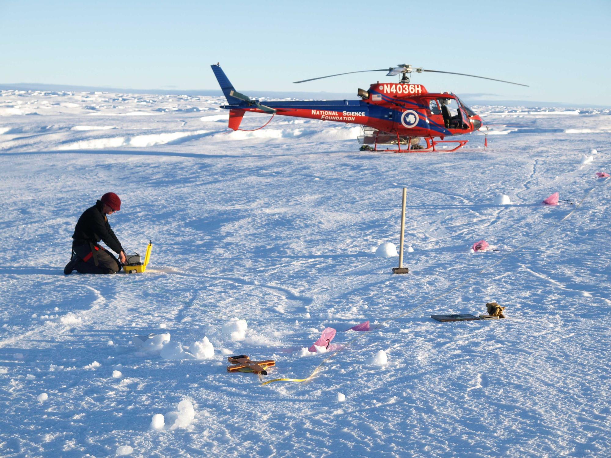 helicopter and woman on ice in Antarctica