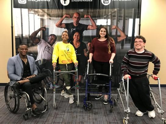 four students in a wheelchair or using walkers