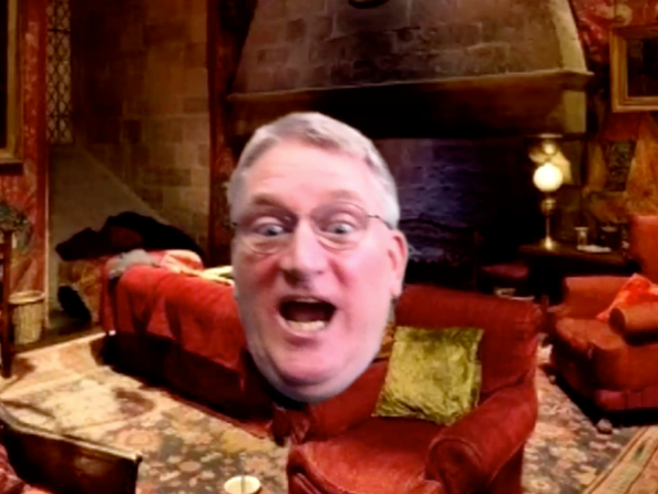 man uses green screen to appear as if his head is floating in front of Harry Potter-themed virtual background