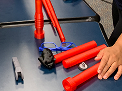Red, 3D-printed pieces are spread out on a table. 