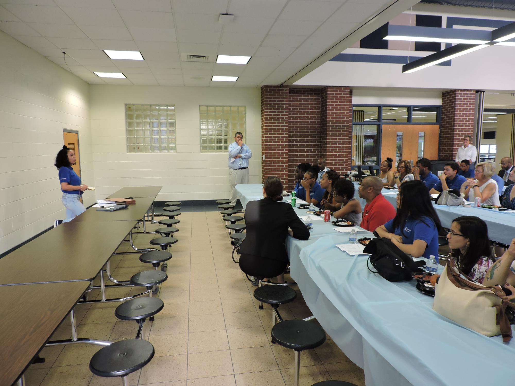 student talking to group in cafeteria