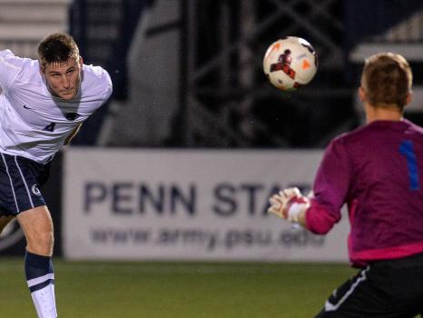 soccer player heading ball into goal