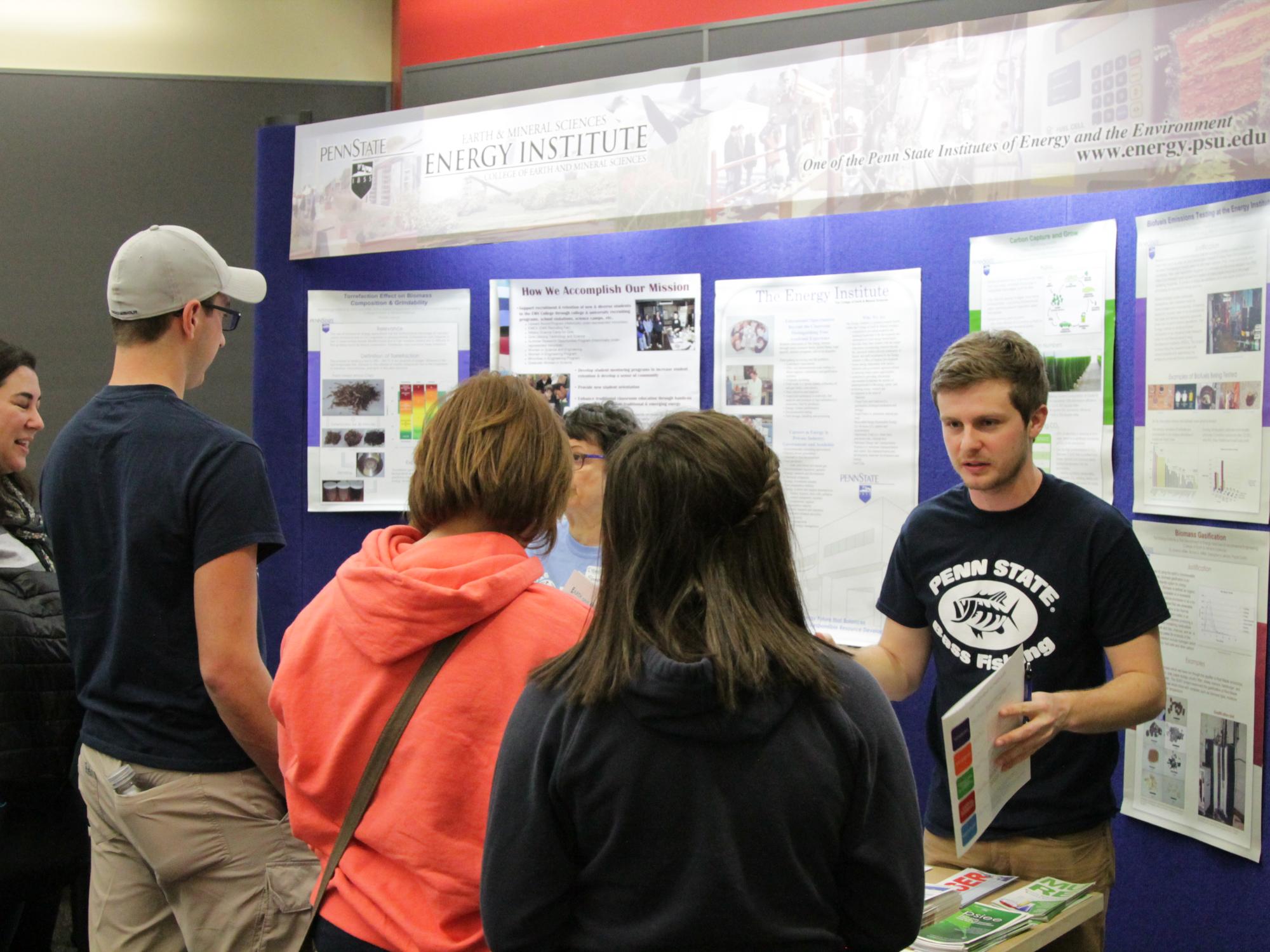 Student talking to parents at informational booth