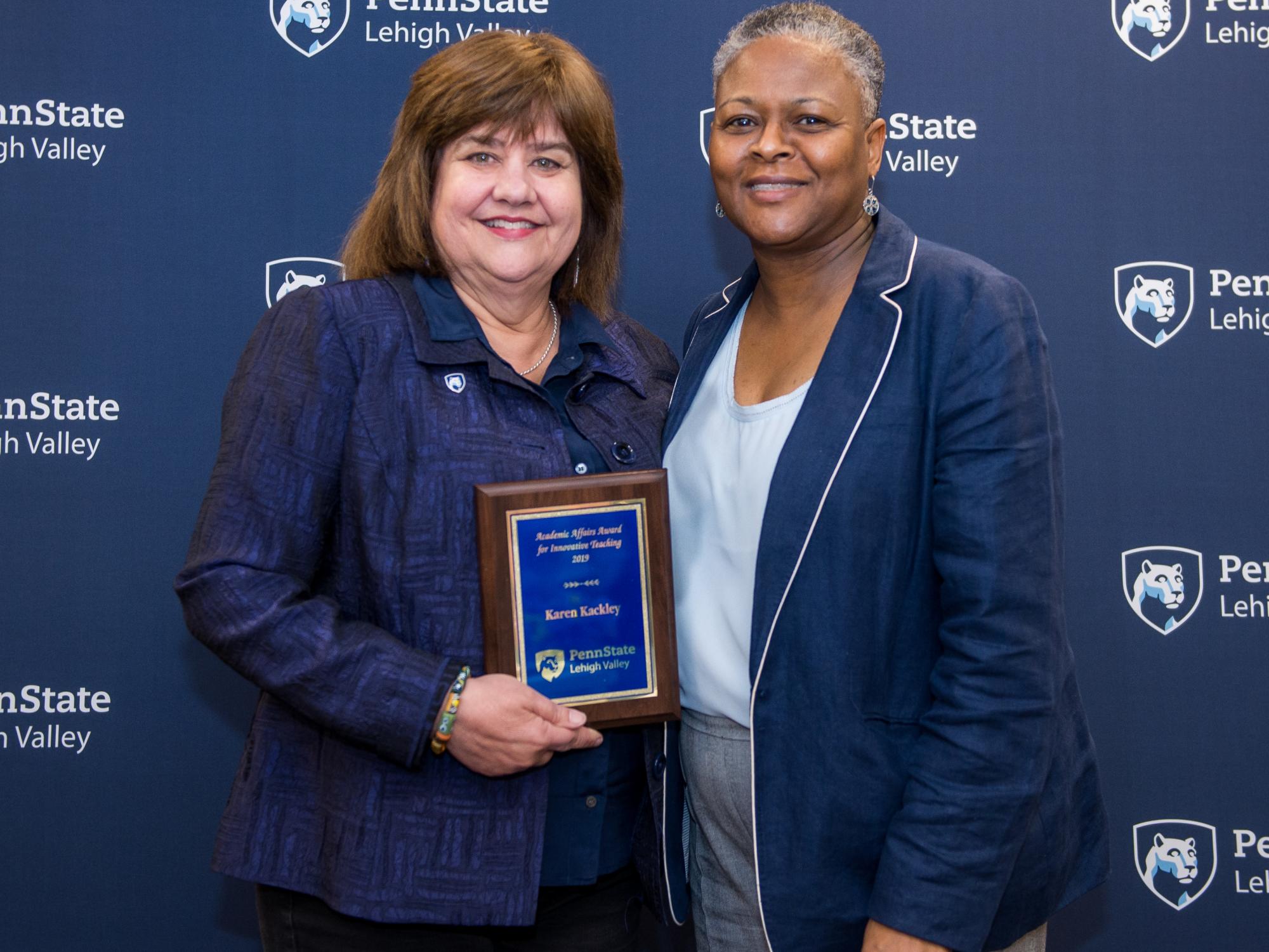 woman getting an award from another woman