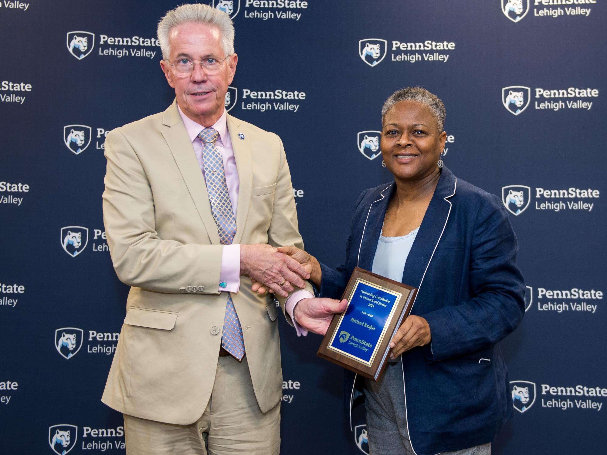 man accepting award from woman