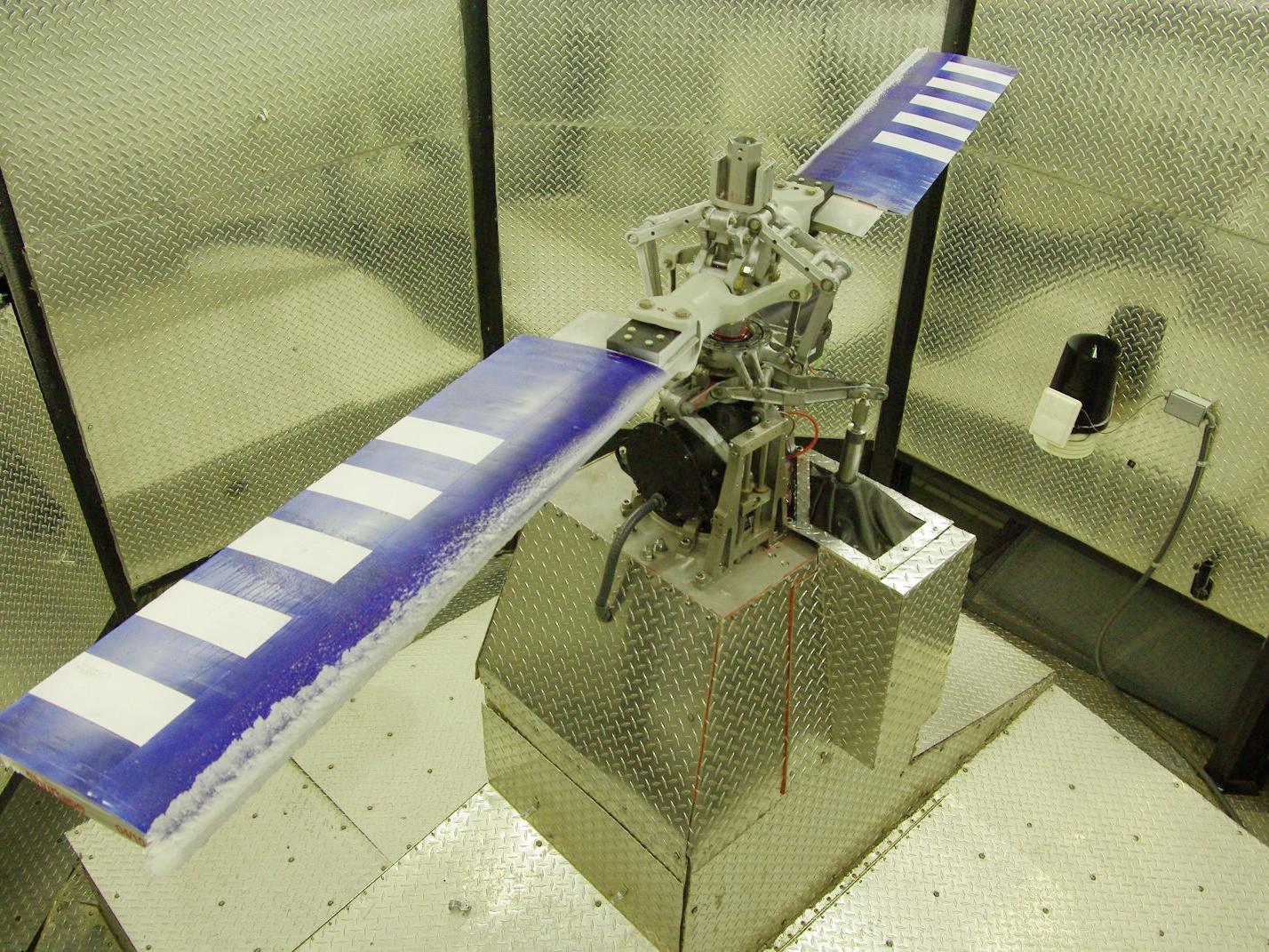 A blue rotor spans a silver chamber. There is ice on the blue blades. 