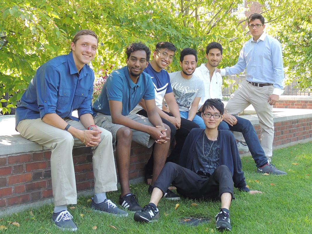 students sitting on brick wall