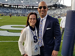 man and woman stand next to eachother on a football field