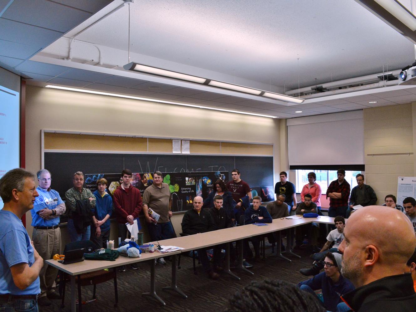 man speaking to crowded classroom