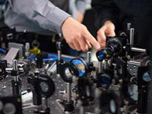 A close-up of a table of equipment with two hands pointing at the equipment 