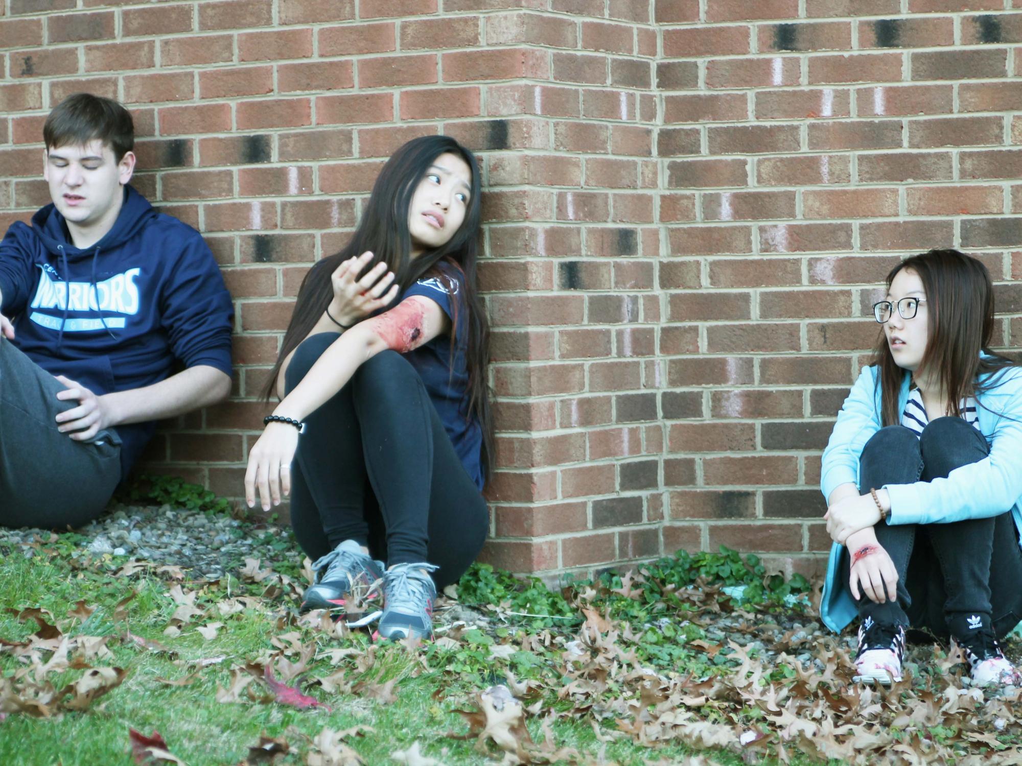 Three "wounded" students sit against the wall during an active shooter exercise at Penn State Beaver
