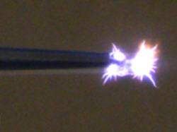 Light bursts out of a black tube.