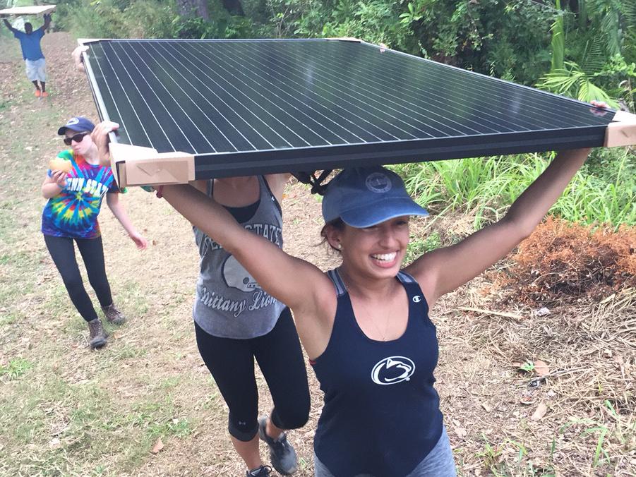 Students carry a solar panel to their installation site in Punta Gorda, a village in Honduras.