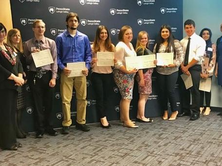 Group of students with faculty members displaying their certificates