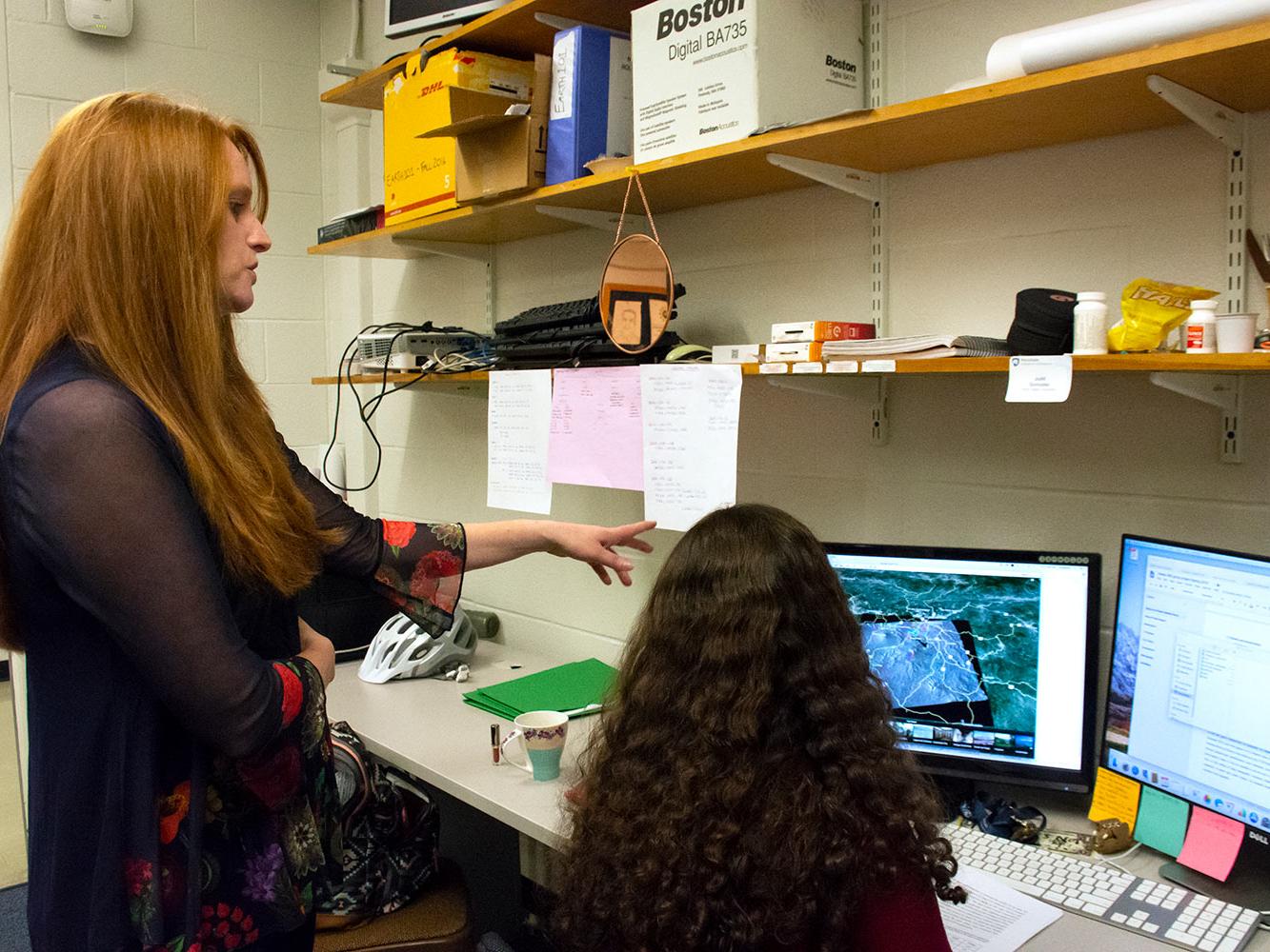 Research Christelle Wauthier stands next to a graduate student, points to a computer screen