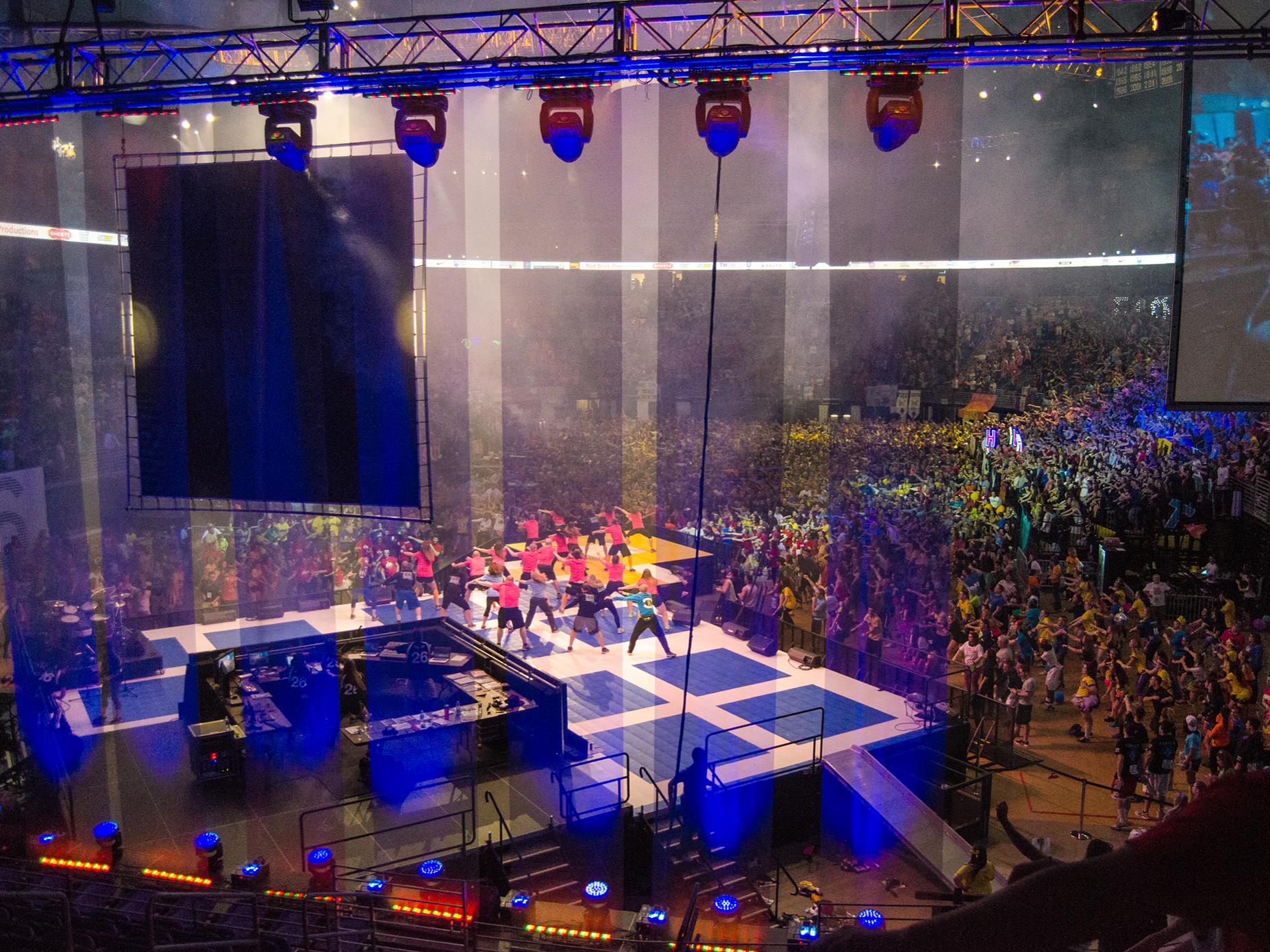 View of the dancers on the Bryce Jordan Center floor from behind the stage