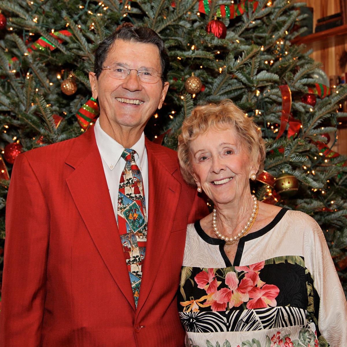 Balgos in festive clothing in front of Christmas tree