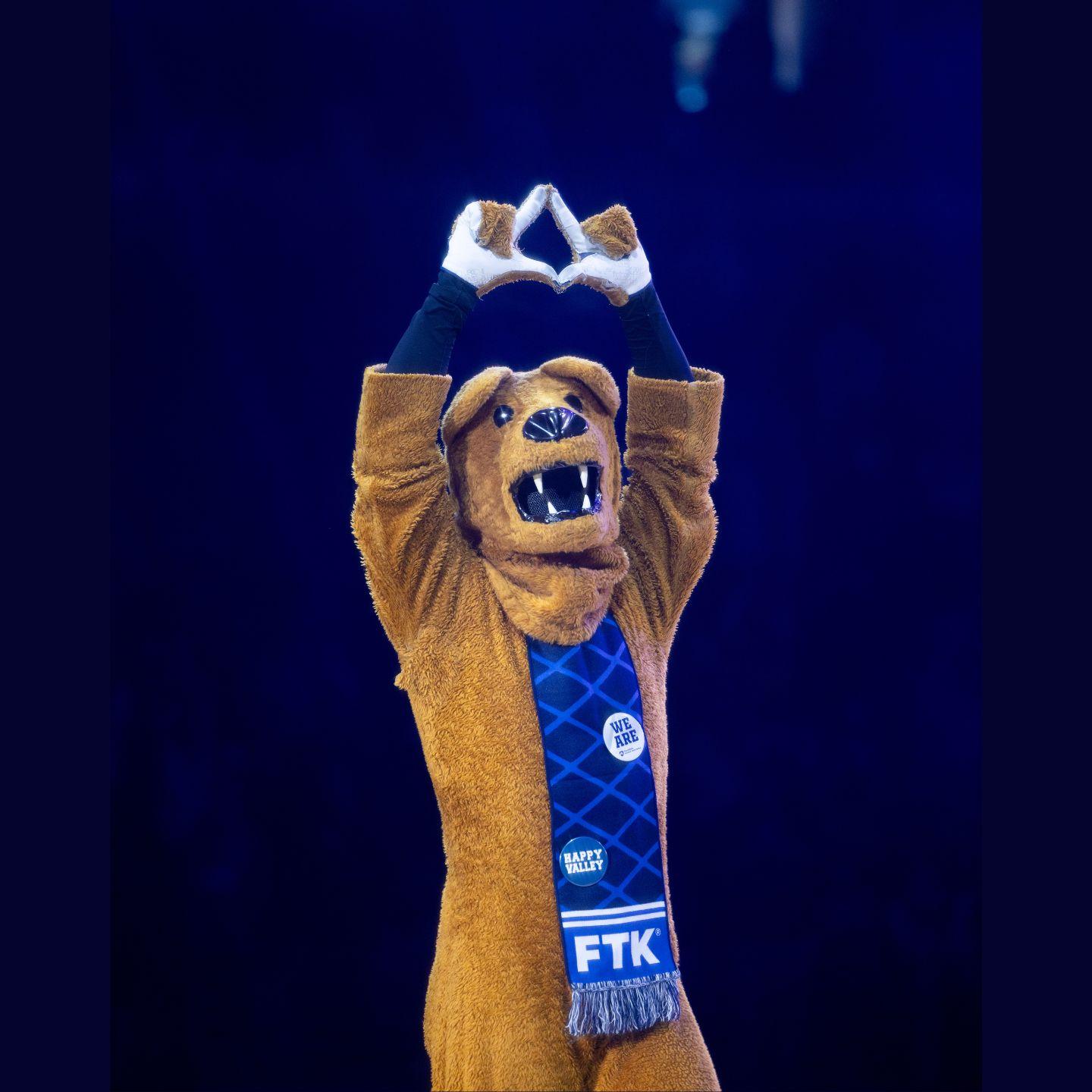 The Nittany Lion makes a diamond with his hands