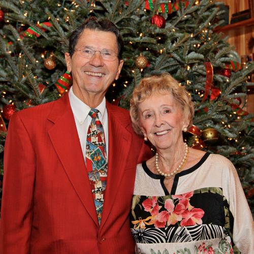 Balgos in festive clothing in front of Christmas tree