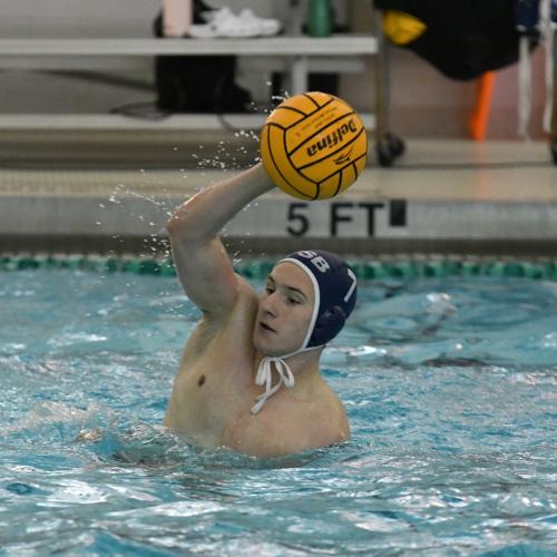 A Penn State Behrend men's water polo player catches the ball.