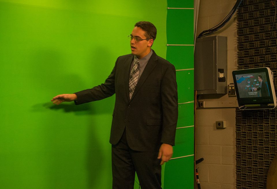 Penn State meteorology student Ben Reppert delivers a forecast in front of the "green screen"